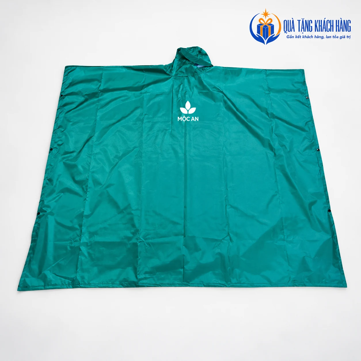 Mô phỏng logo MỘC AN trắng ở vùng trước Poncho xanh ngọc