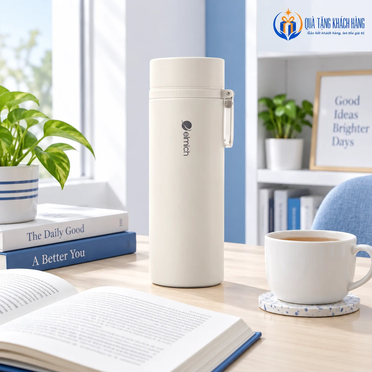 Bình Elmich màu kem đứng cạnh sách mở và cốc ở góc đọc sáng.