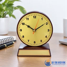 Đồng hồ gỗ mặt đồng ở góc bàn làm việc