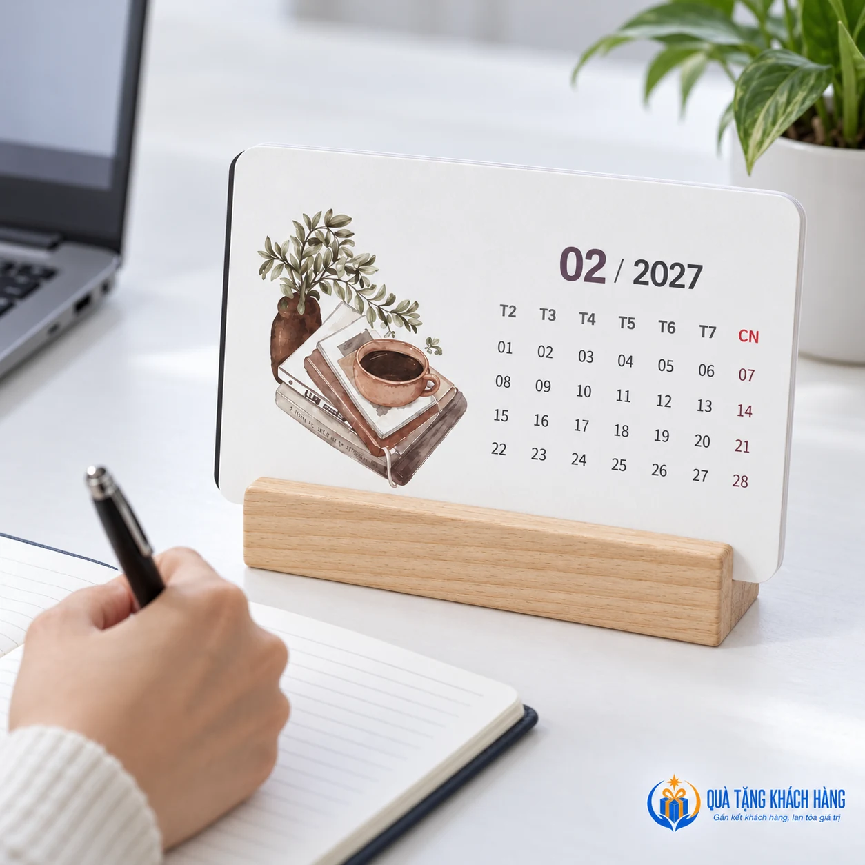 Lịch tháng đặt cạnh sổ tay trên bàn làm việc