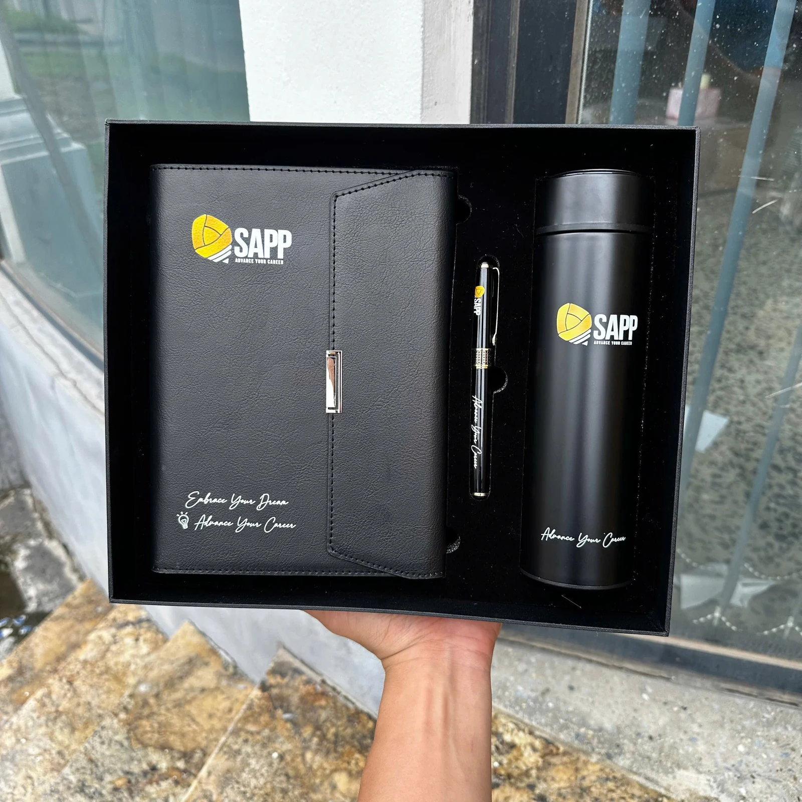 Ảnh thật bộ SAPP gồm sổ, bút và bình đen trong khay.