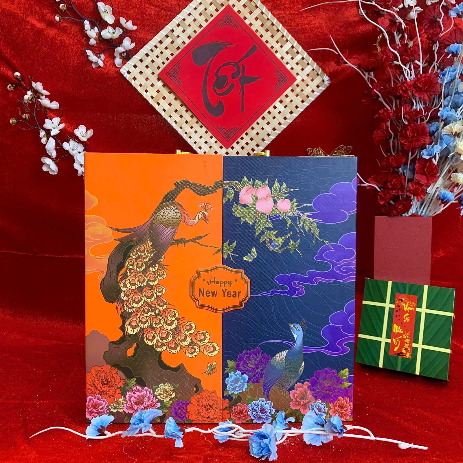 Ảnh thật hộp quà cam xanh họa tiết chim hoa, mặt ngoài có chữ Happy New Year.