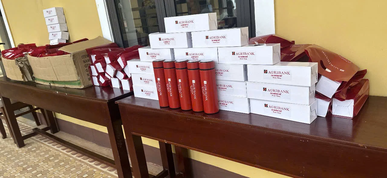 Nhiều bình đỏ, hộp trắng và túi quà cùng mang nhận diện Agribank.
