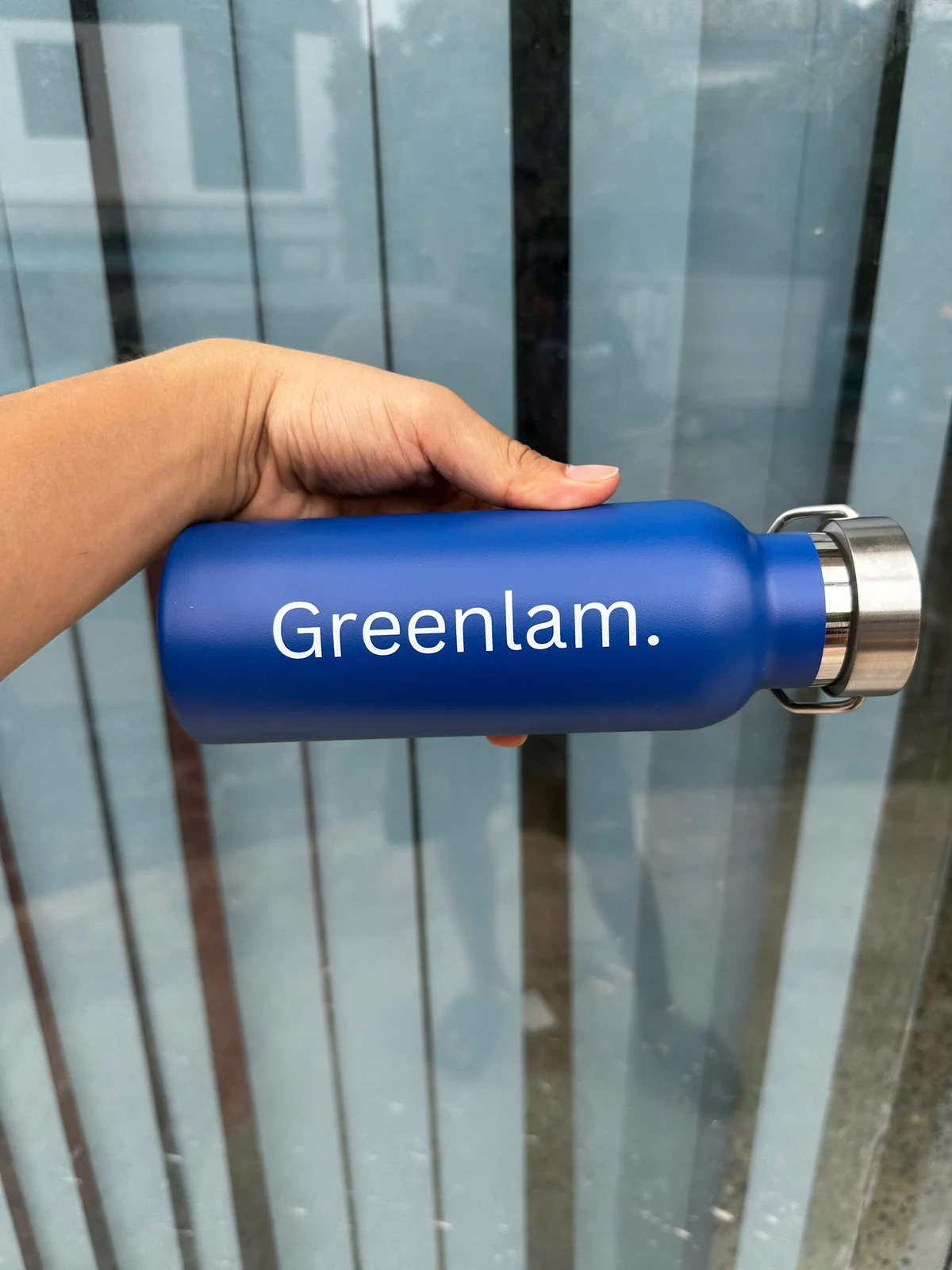Chi tiết chữ Greenlam màu trắng trên thân bình xanh, nắp kim loại có quai.
