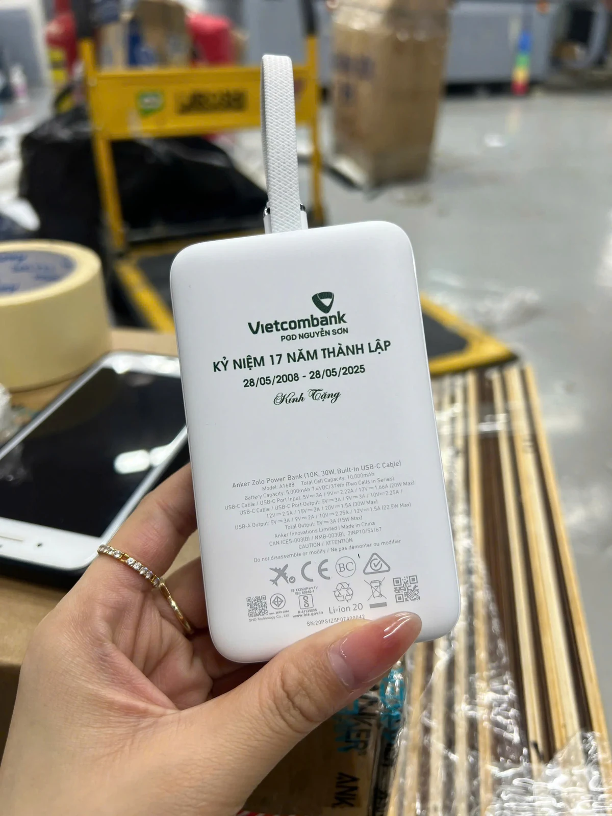 Ảnh nguồn mặt sạc trắng với nhận diện Vietcombank xanh và nhãn thông tin bên dưới.