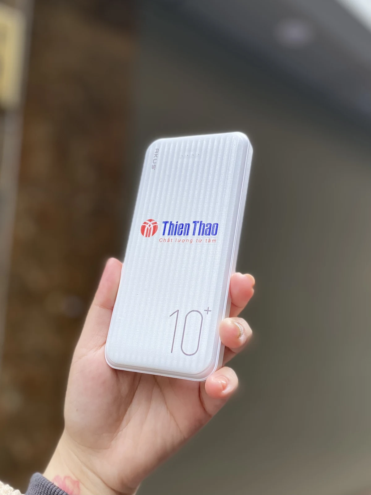 Sạc dự phòng trắng có logo ThienThao ở mặt trước trong ảnh gốc.