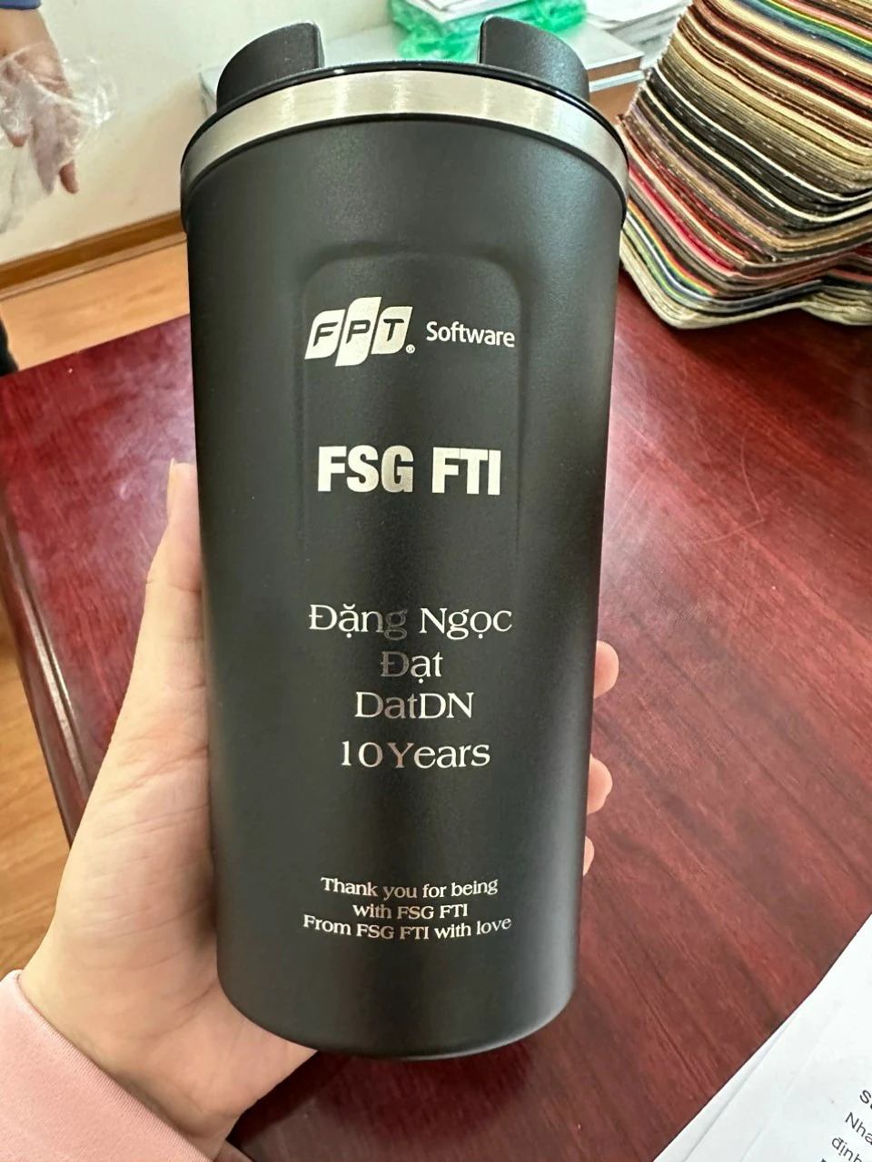 Ly đen có nhận diện FPT Software, FSG FTI và tên Đặng Ngọc Đạt chia hai dòng trong ảnh nguồn.