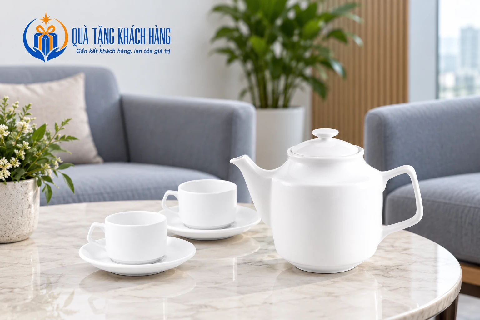 Ấm trà trắng cùng hai chén có đĩa lót trên bàn tiếp khách.